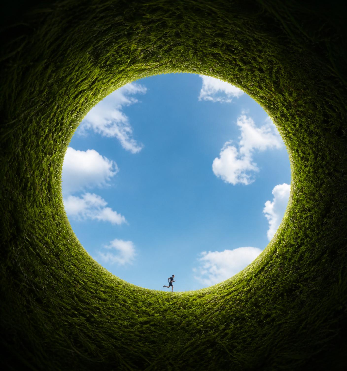 A person moving through an open landscape beneath a bright sky